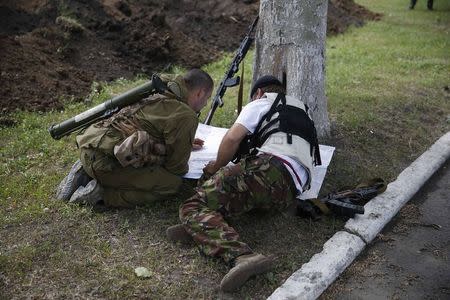 Pro-Russian separatists look at a map on their base in the east Ukrainian city of Donetsk May 30, 2014. REUTERS/Maxim Zmeyev