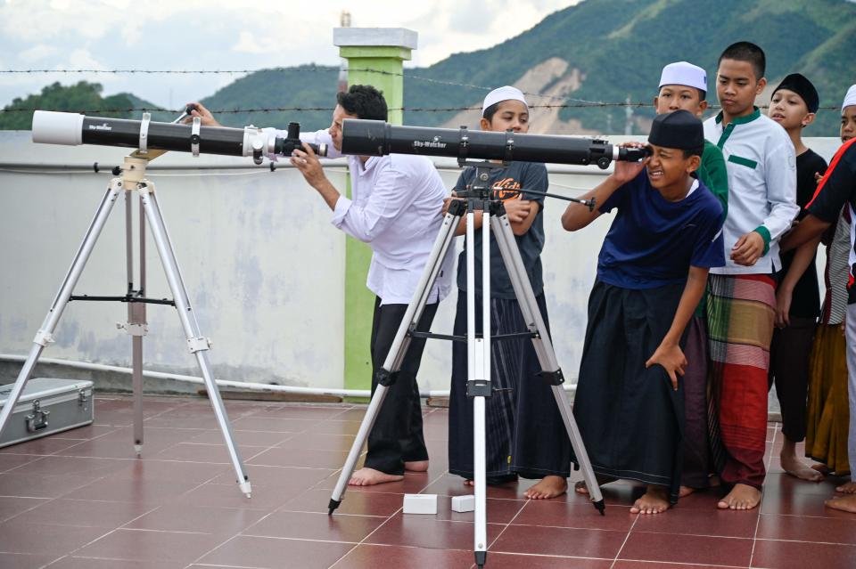 Islamic boarding school students look through telescopes as they prepare to watch a lunar eclipse in Ajun, Indonesia's Aceh province on Nov. 8, 2022.