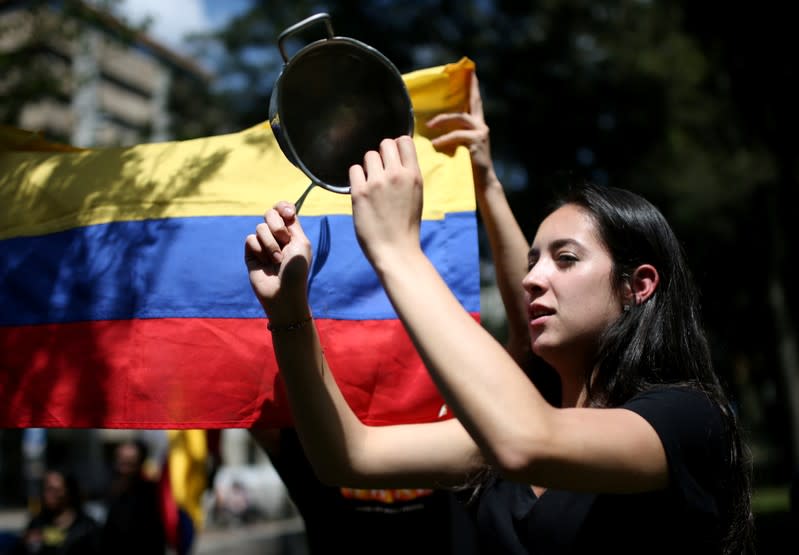 A demonstrator bangs a pot during a protest in National Park as national strike continues in Bogota