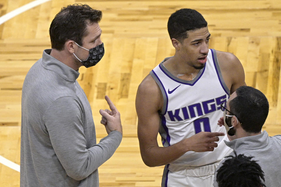 Sacramento Kings coach Luke Walton, left, talks to guard Tyrese Haliburton (0) during a timeout in the second half of the team's NBA basketball game against the Orlando Magic, Wednesday, Jan. 27, 2021, in Orlando, Fla. (AP Photo/Phelan M. Ebenhack)