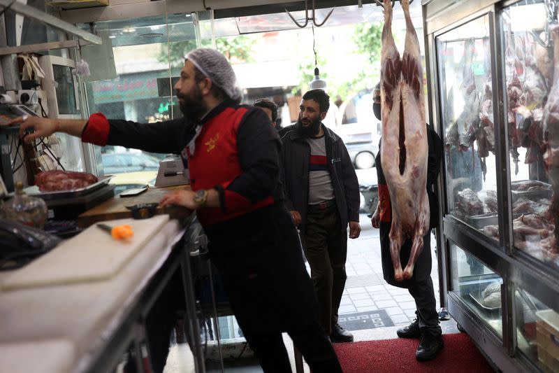 An Iranian man buys in a butcher shop in Tehran