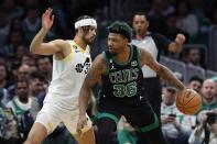 Boston Celtics' Marcus Smart (36) looks to move against Utah Jazz's Johnny Juzang (33) during the first half of an NBA basketball game, Friday, March 31, 2023, in Boston. (AP Photo/Michael Dwyer)