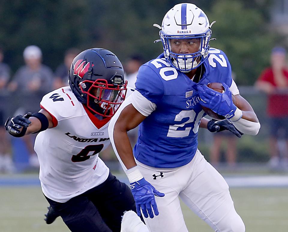 St. Xavier High School running back Charles Kellom is chased down by Malik Hartford of Lakota West during a football game at Ballaban Field in Cincinnati Aug. 20, 2021.