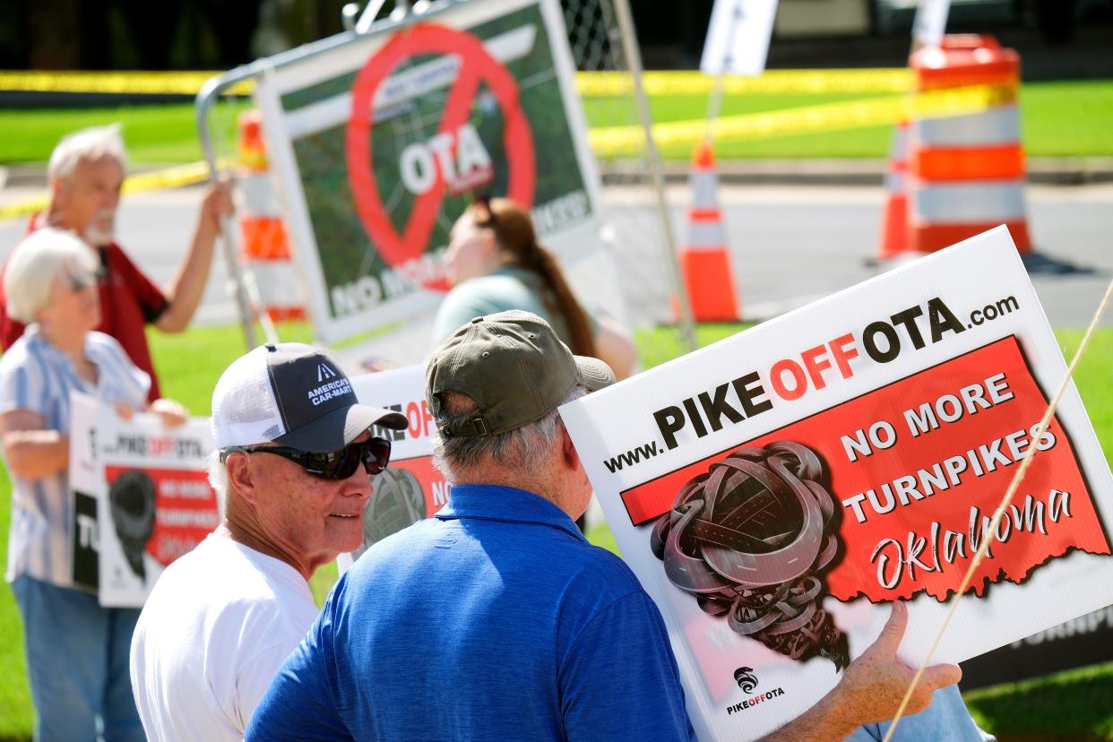 Members of Pike Off OTA, a group opposed to portions of the ACCESS turnpike expansion, hold signs as they protest Tuesday, Aug. 30, 2022, outside a fundraiser for Gov. Kevin Stitt at the Association of Oklahoma General Contractors.