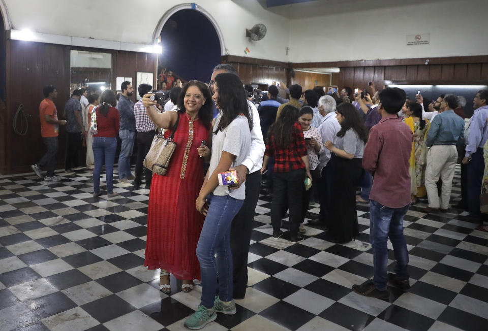 In this early Friday, March 31, 2017 photo, movie buffs sing and take selfies after watching the final movie screening at Regal Theater in New Delhi, India. From Bollywood superstars to political heavyweights, the theater had hosted some of India’s biggest names over more than eight decades. But with nostalgic theater-goers singing their way to the exits after a final showing of a Bollywood classic, the iconic New Delhi theater has closed its doors to make way for a multiplex. (AP Photo/Manish Swarup)