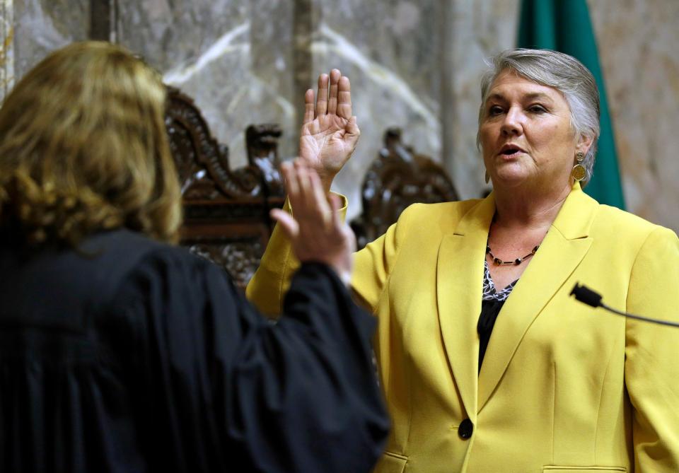 In this Jan. 9, 2017 file photo, Sen. Maureen Walsh, R-Walla Walla, right, takes the oath of office on the opening day of the 2017 legislative session at the Capitol in Olympia, Wash. Sen. Walsh has angered nurses by commenting in a speech that some nurses may spend a lot of time playing cards in rural hospitals.