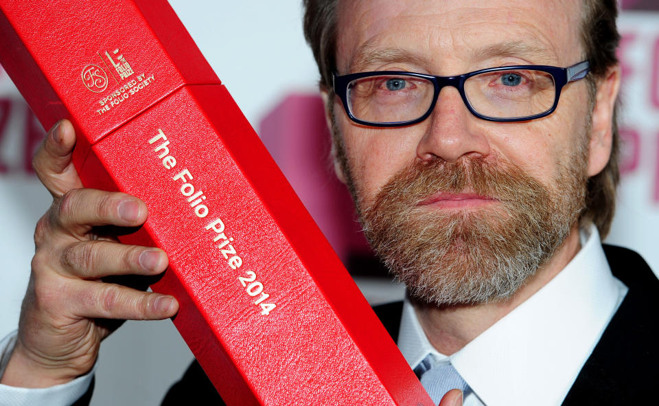 George Saunders holds up a trophy after winning the Folio Prize at the St Pancras Renaissance Hotel in London, Monday, March 10, 2014. The American writer has won the 40,000 pound ($67,000) Folio Prize for literature with his humorous and disturbing short-story collection "Tenth of December." The chair of the judging panel, poet Lavinia Greenlaw, said Monday that Saunders' "darkly playful" stories explore "the human self under ordinary and extraordinary pressure." Saunders beat seven other finalists, including Kent Haruf, Rachel Kushner, Anne Carson and Eimear McBride. (AP Photo/PA, Ian West) UNITED KINGDOM OUT