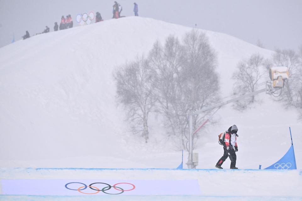 The course is cleared temporarily due to snowfall in the snowboard mixed team cross quarter-finals during the Beijing 2022 Winter Olympic Games (AFP via Getty Images)