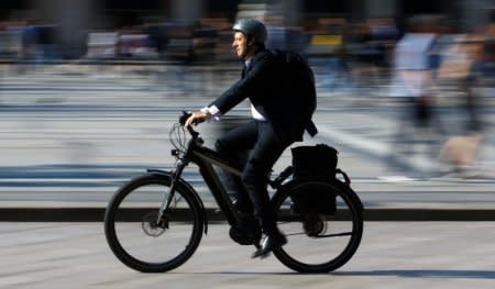 FILE PHOTO -  A man rides an electric bicycle, also known as an e-bike, in downtown Milan, Italy, May 18, 2018. REUTERS/Stefano Rellandini