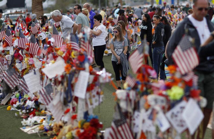 FILE - People visit a makeshift memorial honoring the victims of the Oct. 1 mass shooting on Nov. 12, 2017, in Las Vegas. A Trump administration ban on bump stocks, devices that enable a shooter to rapidly fire multiple rounds from semi-automatic weapons after an initial trigger pull, was struck down Friday, Jan. 6, 2023, by a federal appeals court in New Orleans. The ban was instituted after a sniper using bump stock-equipped weapons massacred dozens of people in Las Vegas in 2017. (AP Photo/John Locher, File)