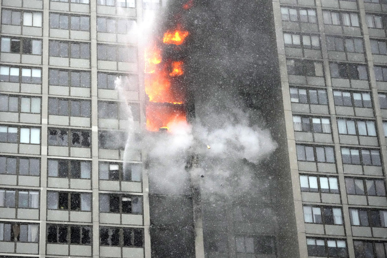 Flames leap skyward out of the Harper Square cooperative residential building in the Kenwood neighborhood of Chicago, Wednesday, Jan. 25, 2023. (AP Photo/Charles Rex Arbogast)