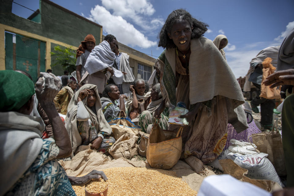 An Ethiopian woman leaves with a portion of yellow split peas after it was distributed by the Relief Society of Tigray in the town of Agula, in the Tigray region of northern Ethiopia, on Saturday, May 8, 2021. The 15 kilograms of wheat, half a kilogram of peas and some cooking oil per person, to last a month — was earmarked only for the most vulnerable. That included pregnant mothers and elderly people. (AP Photo/Ben Curtis)