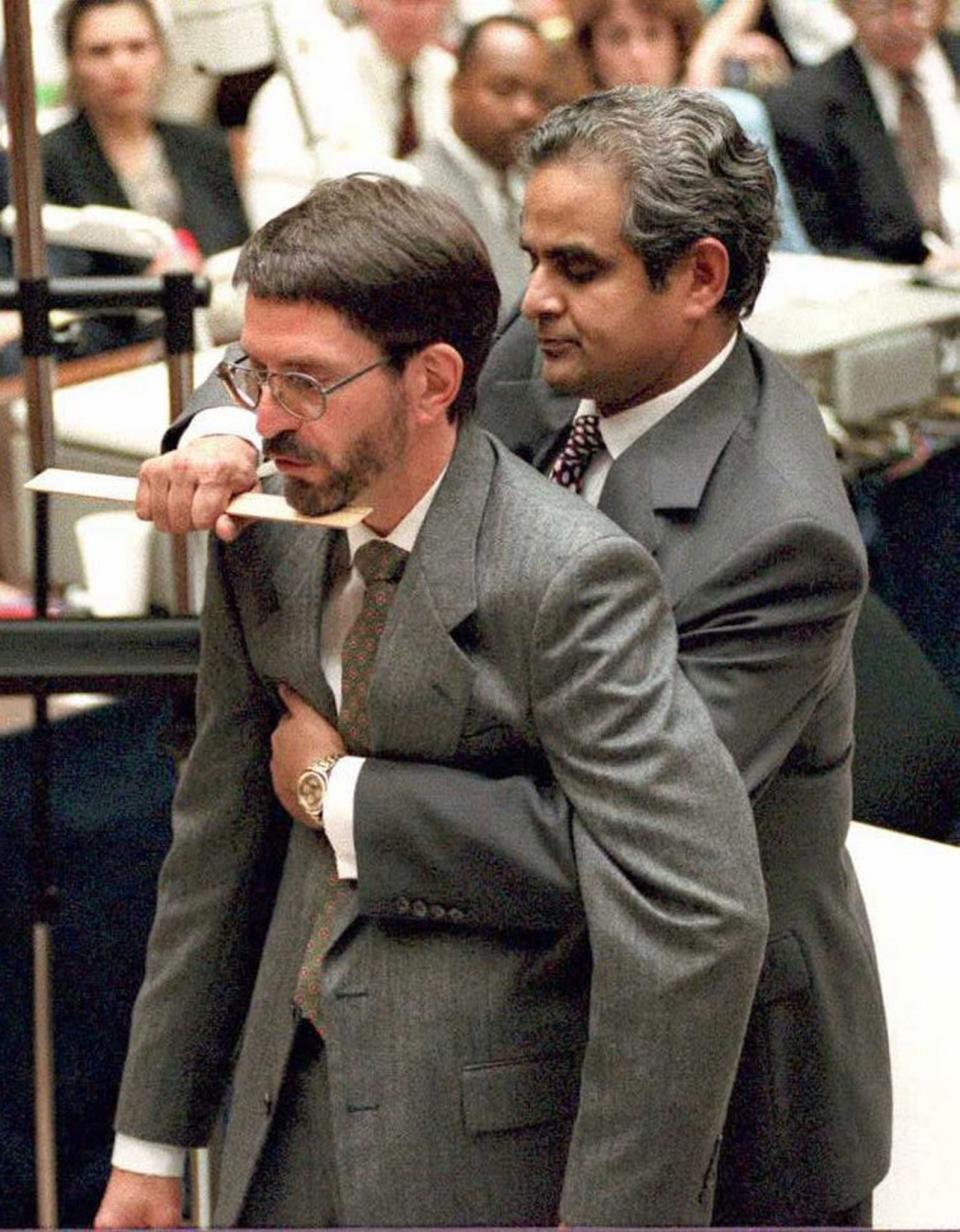 <p>Los Angeles County Coroner Dr. Lakshmanan Sathyavagiswaram (R) demonstrates on prosecutor Brian Kelberg (L) the fatal stab wound to victim Ronald Goldman during the O.J. Simpson murder trial in Los Angeles, Calif., June 13, 1995. (Photo: Myung J. Chun/AFP/Getty Images) </p>