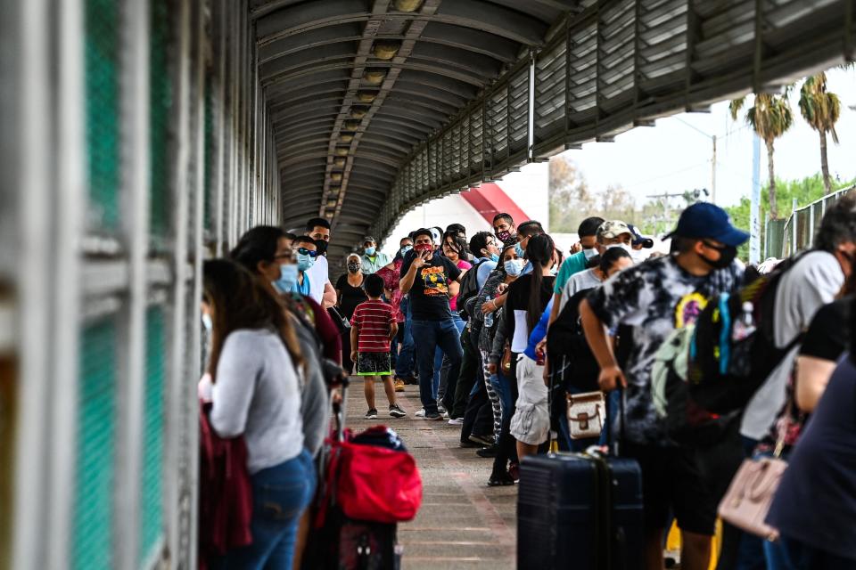 Migrants mostly form Central America wait in line to cross the border at the Gateway International Bridge into the US from Matamoros, Mexico to Brownsville, Texas, on March 15. (Photo: CHANDAN KHANNA via Getty Images)