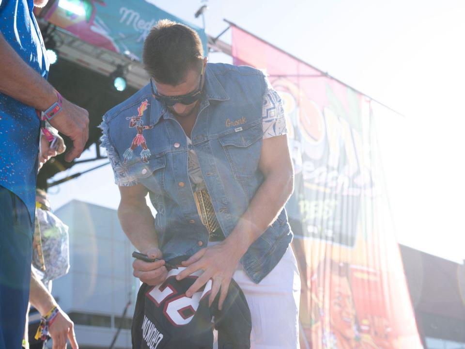 Rob Gronkowski signs merch onstage at Gronk Beach.