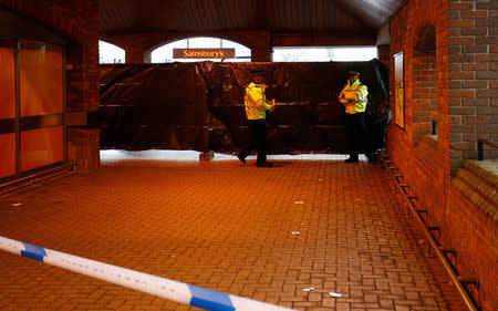 Police officers work behind a cordon at a supermarket near the bench where former Russian intelligence officer Sergei Skripal and his daughter Yulia were found poisoned, in Salisbury, Britain, March 12, 2018. REUTERS/Henry Nicholls