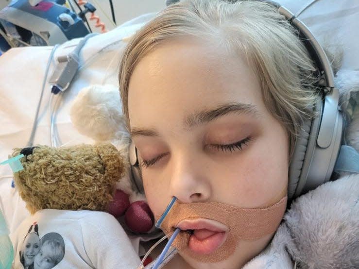 Archie Battersbee lies in a coma in hospital with tubes in his mouth and nose. He is wearing headphone and has a teddy bear next to him.