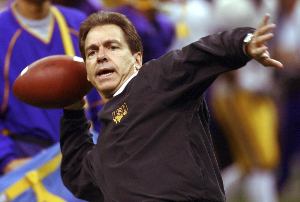 FILE - LSU coach Nick Saban throws passes to his defensive backs during practice at the Louisiana Superdome in New Orleans on Thursday, Jan. 1, 2004. Nick Saban is retiring after leading Alabama to six national titles in 17 seasons and winning another at LSU, Wednesday, Jan. 10, 2024. (AP Photo/Dave Martin, File)