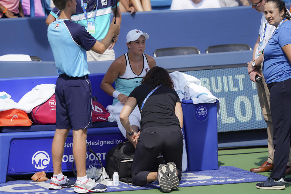 Ashleigh Barty, of Australia, receives a medical time-out during a match against Svetlana Kuznetsova, of Russia, during the Western & Southern Open tennis tournament, Saturday, Aug. 17, 2019, in Mason, Ohio. (AP Photo/John Minchillo)