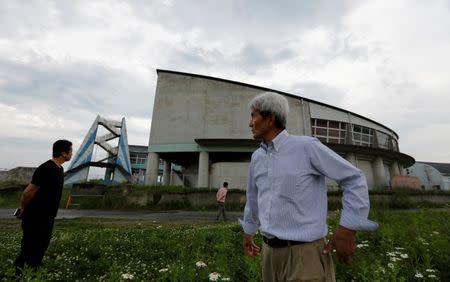 Tour guide Katsuaki Shiga (R) and tourists visit the Ukedo elementary school, damaged by the March 11, 2011 tsunami, at an area devastated by the disaster, near Tokyo Electric Power Co's (TEPCO) tsunami-crippled Fukushima Daiichi nuclear power plant, in Namie town, Fukushima prefecture, Japan May 17, 2018. Picture taken May 17, 2018. REUTERS/Toru Hanai