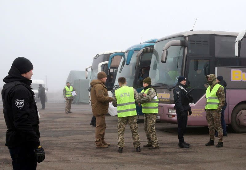 Ukrainian law enforcement officers stand guard near buses for pro-Russian rebels before prisoner of war exchange in Donetsk region