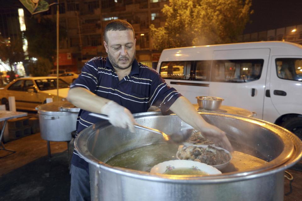 In this Sunday, Oct. 30, 2016 photo, chef, Mohammed Ahmed, prepare food for customers at his restaurant in central Baghdad, Iraq. There are any number of delicious recipes that put the Iraqi city of Mosul on the culinary map long before it was devoured by the Islamic State group. And there is pache _ the head, intestines and other parts of animals, boiled in giant vats. (AP Photo/Hadi Mizban)