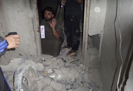 A man inspects the damage in a communication station where Islamist State militants say a U.S. drone crashed into in Raqqa September 23, 2014. REUTERS/Stringer