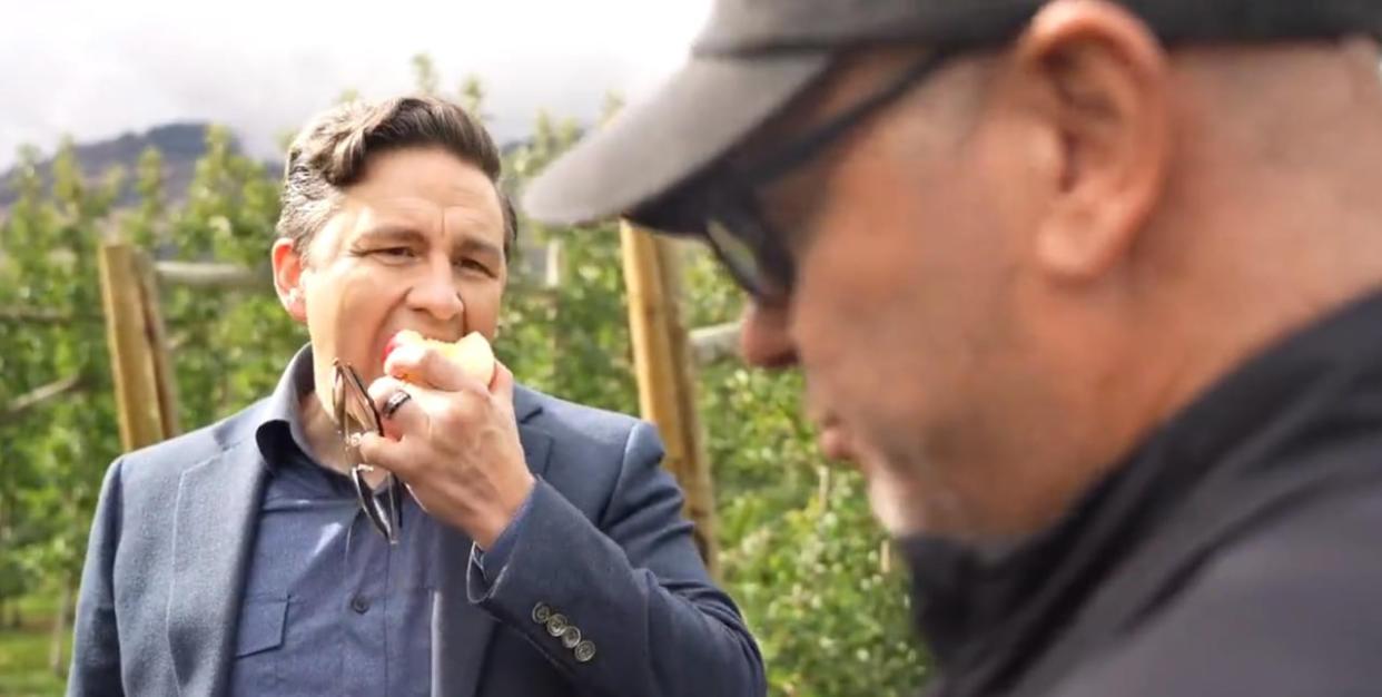 Conservative Leader Pierre Poilievre eats an apple while speaking to a journalist.  (Screengrab/Pierre Poilievre/X - image credit)