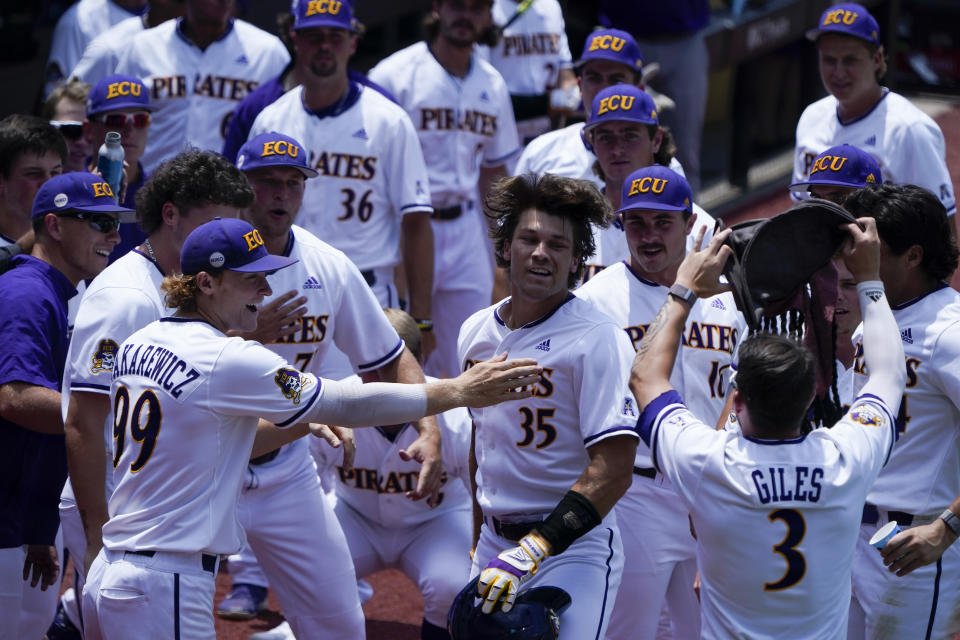 East Carolina's Bryson Worrell celebrates at the dugout after a home run against Texas during the fifth inning of an NCAA college super regional baseball game Friday, June 10, 2022, in Greenville, N.C. (AP Photo/Chris Carlson)