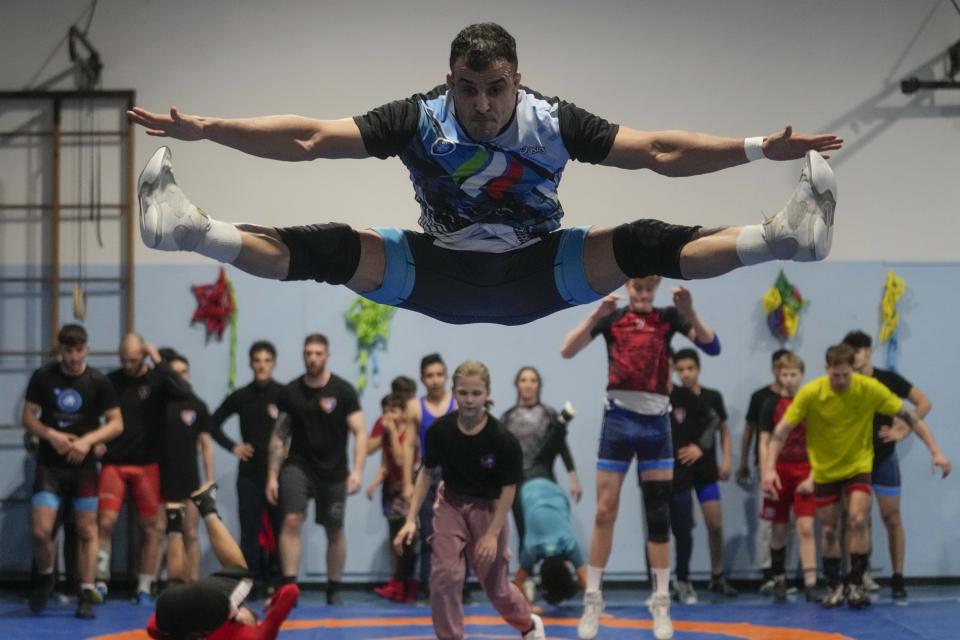 Iranian wrestler Iman Mahdavi, 28, practices at the Lotta Club Seggiano gym, in Pioltello, northern Italy, Wednesday, Feb. 28, 2024. Mahdavi fled his home country in fear of his life in October 2020. Now, he will compete in Paris as part of the Refugee Olympic Team. (AP Photo/Luca Bruno)