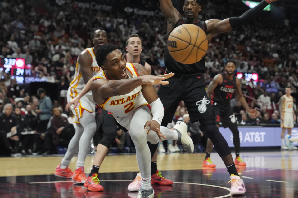 Atlanta Hawks guard Trent Forrest (2) passes the ball under pressure from Miami Heat center Bam Adebayo (13) during the first half of an NBA basketball game, Friday, Jan. 19, 2024, in Miami. (AP Photo/Marta Lavandier)