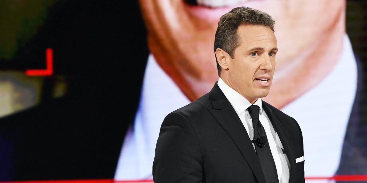 Chris Cuomo stands in front of a blown up portrait of himself.