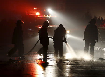 Fire-fighters wash the blast site, in an area close to the Russian embassy in the west of the capital of Kabul, Afghanistan January 20, 2016. REUTERS/Ahmad Masood