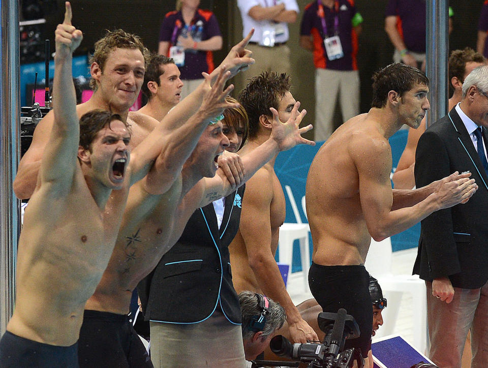 USA swimmer Michael Phelps (right) applaudes as the French 4 x 100 Mens Freestyle team (left) react after narrowly defeating the USA to win the final of event a at the Olympic Games in London, Sunday, July 29, 2012. (AAP Image/Dave Hunt) NO ARCHIVING