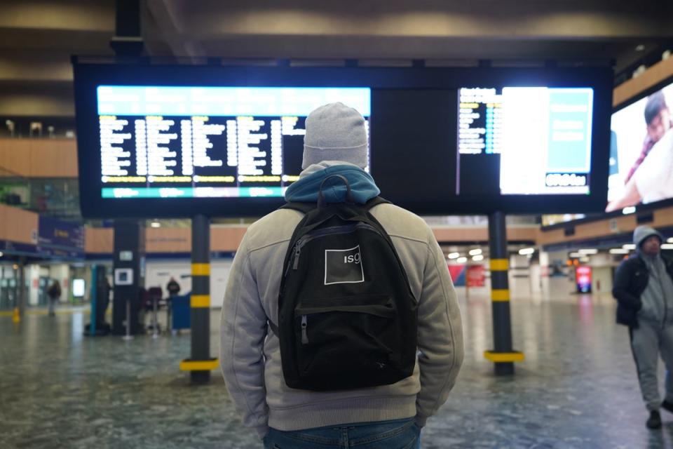 A man looks at the departures board at Euston train station in London (PA)