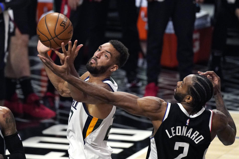 Utah Jazz center Rudy Gobert, left, reaches for a rebound along with Los Angeles Clippers forward Kawhi Leonard during the second half of Game 3 of a second-round NBA basketball playoff series Saturday, June 12, 2021, in Los Angeles. (AP Photo/Mark J. Terrill)