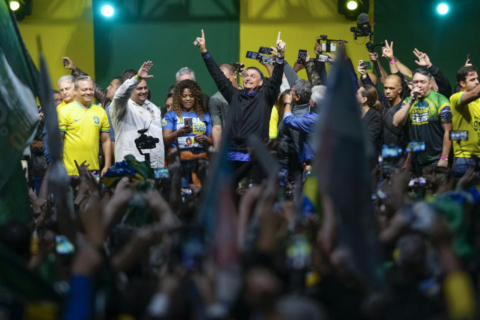 FILE - Brazilian President Jair Bolsonaro, center, who is running for a second term, greets supporters during a campaign rally in Santos, Brazil, Sept. 28, 2022. Despite the smoke clogging the air of entire Amazon cities, state elections have largely ignored environmental issues. Bolsonaro is seeking a second four-year term against Luiz Inácio Lula da Silva, who ruled Brazil between 2003 and 2010 and leads the polls. (AP Photo/Andre Penner, File)