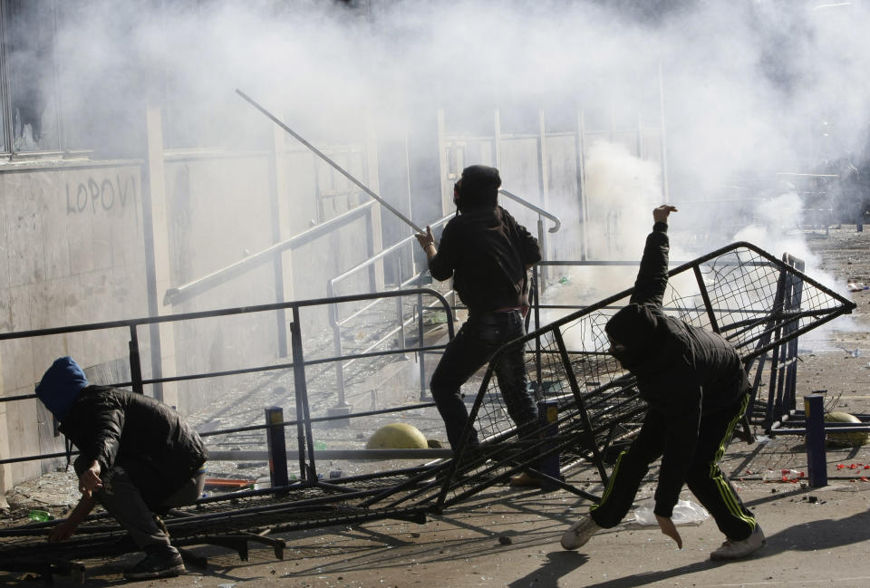 Bosnian protesters approach a local government building, during a protest, in the Bosnian town of Tuzla, Friday, Feb. 7, 2014. Bosnian protesters stormed and set ablaze local government buildings in three Bosnian cities on Friday in fury over unemployment and rampant corruption. At least 90 people were injured. (AP Photo/Amel Emric)