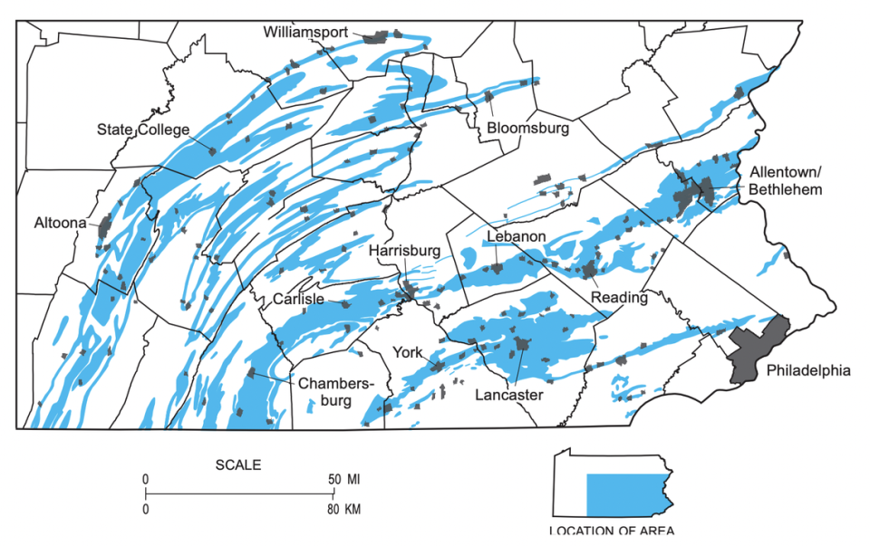 Many major population centers (gray) in central and eastern Pennsylvania sit atop layers of carbonate bedrock (blue), which is easily eroded and associated with sinkholes.