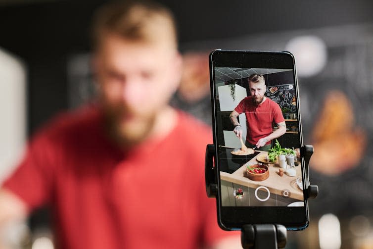 Phone films man cooking in kitchen.