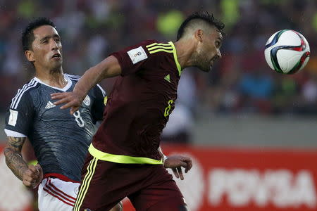 Venezuela's Gabriel Cichero (R) fights for the ball with Paraguay's Lucas Barrios during their 2018 World Cup qualifying soccer match at Cachamay stadium in Puerto Ordaz, October 8, 2015. REUTERS/Carlos Garcia Rawlins