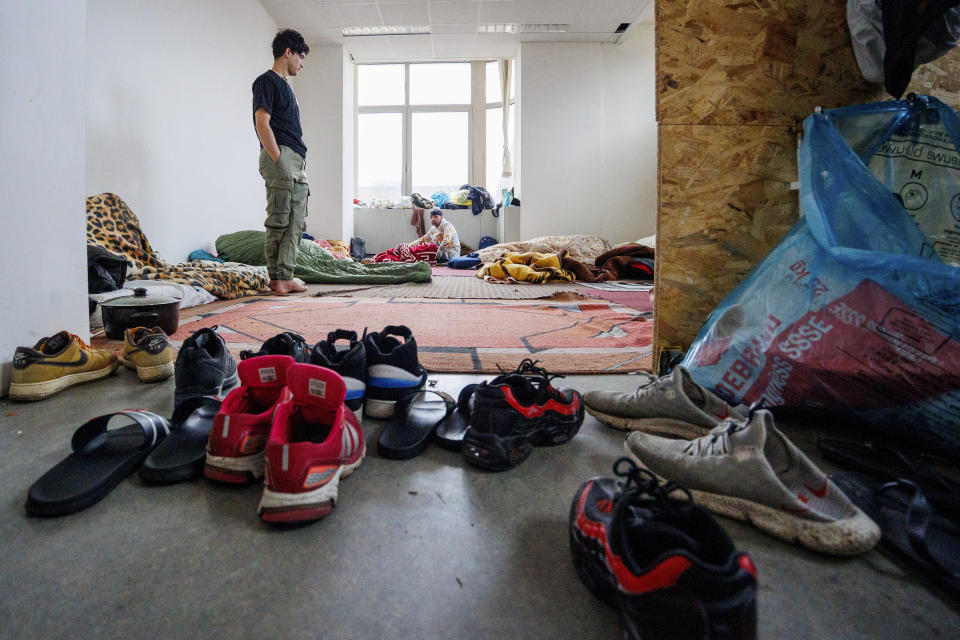 Two men, who identified themselves as Najibullah, left, and Roz Amin Khan, right, in their sleeping quarters of a squatted building in Brussels, Tuesday, Jan. 31, 2023. Many refugees and asylum-seekers are literally left out in the cold for months as the European Union fails to get its migration system working properly. And most talk is about building fences and repatriation instead of working to improve a warm embrace for people fleeing nations like Afghanistan where the Taliban has taken over. (AP Photo/Olivier Matthys)