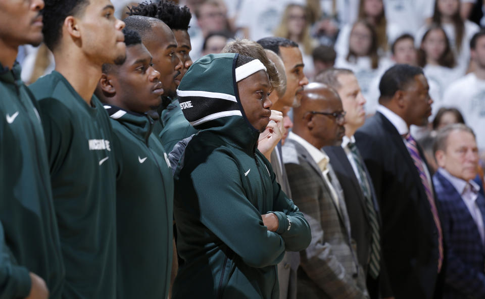 Michigan State's Cassius Winston, center, stands with teammates during a moment of silence in honor of Winston's younger brother, Zachary, before the team's NCAA college basketball game against Binghamton, Sunday, Nov. 10, 2019, in East Lansing, Mich. Michigan State won 100-47. (AP Photo/Al Goldis)