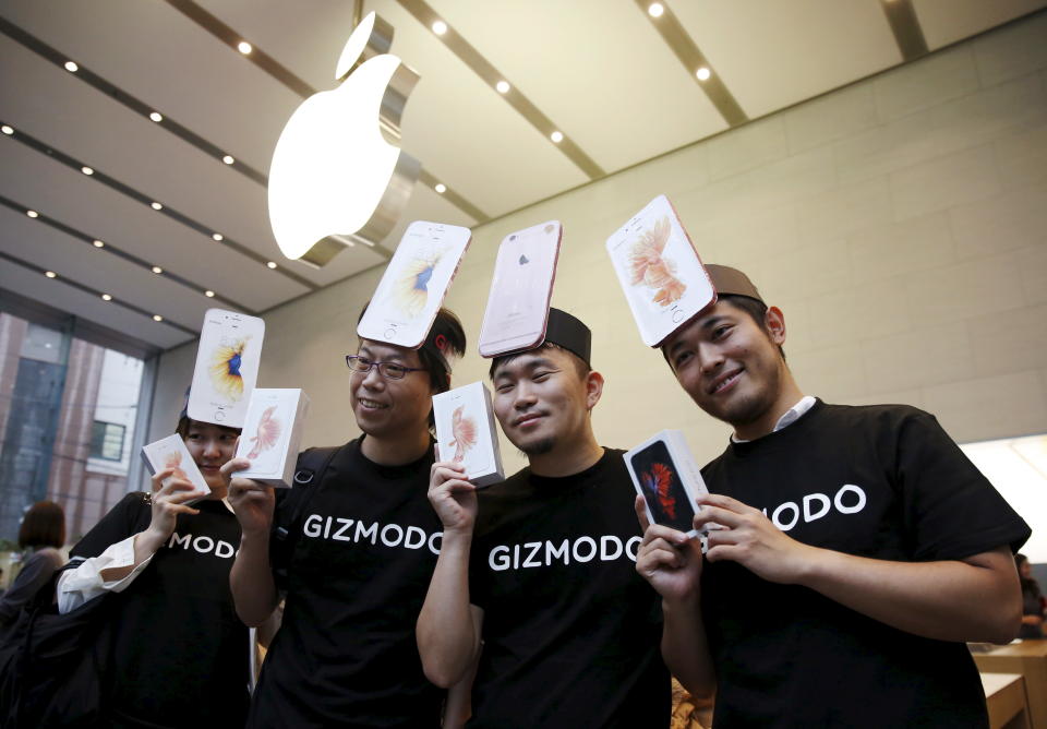 Japanese Makiko Maeda (L), 28, and her colleagues display their iPhone 6s after purchasing them at the Apple Store at Tokyo's Omotesando shopping district September 25, 2015. The new iPhone 6s and 6s Plus arrived in stores and at consumers' doorsteps on Friday, kicking off a sales cycle that will be scrutinized for signs of how much juice Apple's marquee product has left. REUTERS/Issei Kato