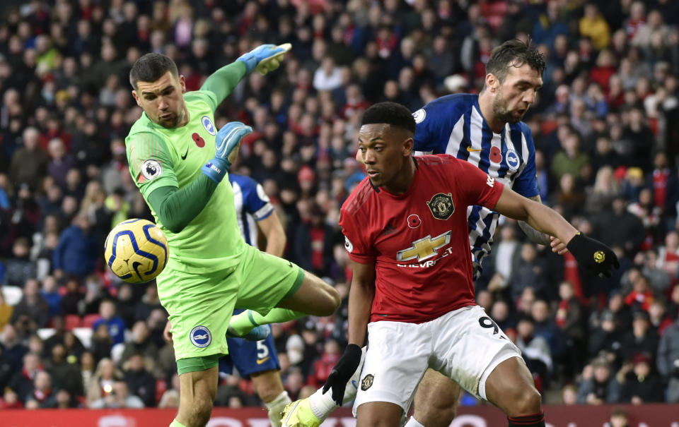 Brighton's goalkeeper Mathew Ryan, left, makes a save in front of Manchester United's Anthony Martial during the English Premier League soccer match between Manchester United and Brighton and Hove Albion, at the Old Trafford stadium in Manchester, England, Sunday, Nov. 10, 2019. (AP Photo/Rui Vieira)