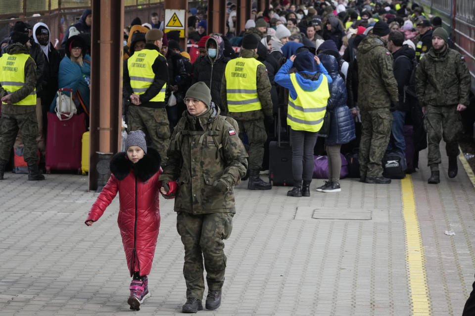 FILE - A child is accompanied by a soldier as refugees from Ukraine arrive to the railway station in Przemysl, Poland, Feb. 27, 2022. Around 2.5 million people have fled Ukraine in the two weeks since Russia invaded. Most have fled to the European Union. (AP Photo/Czarek Sokolowski, File)