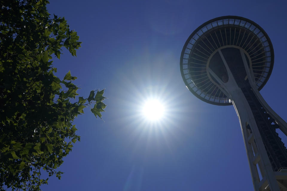 The sun shines near the Space Needle in Seattle.