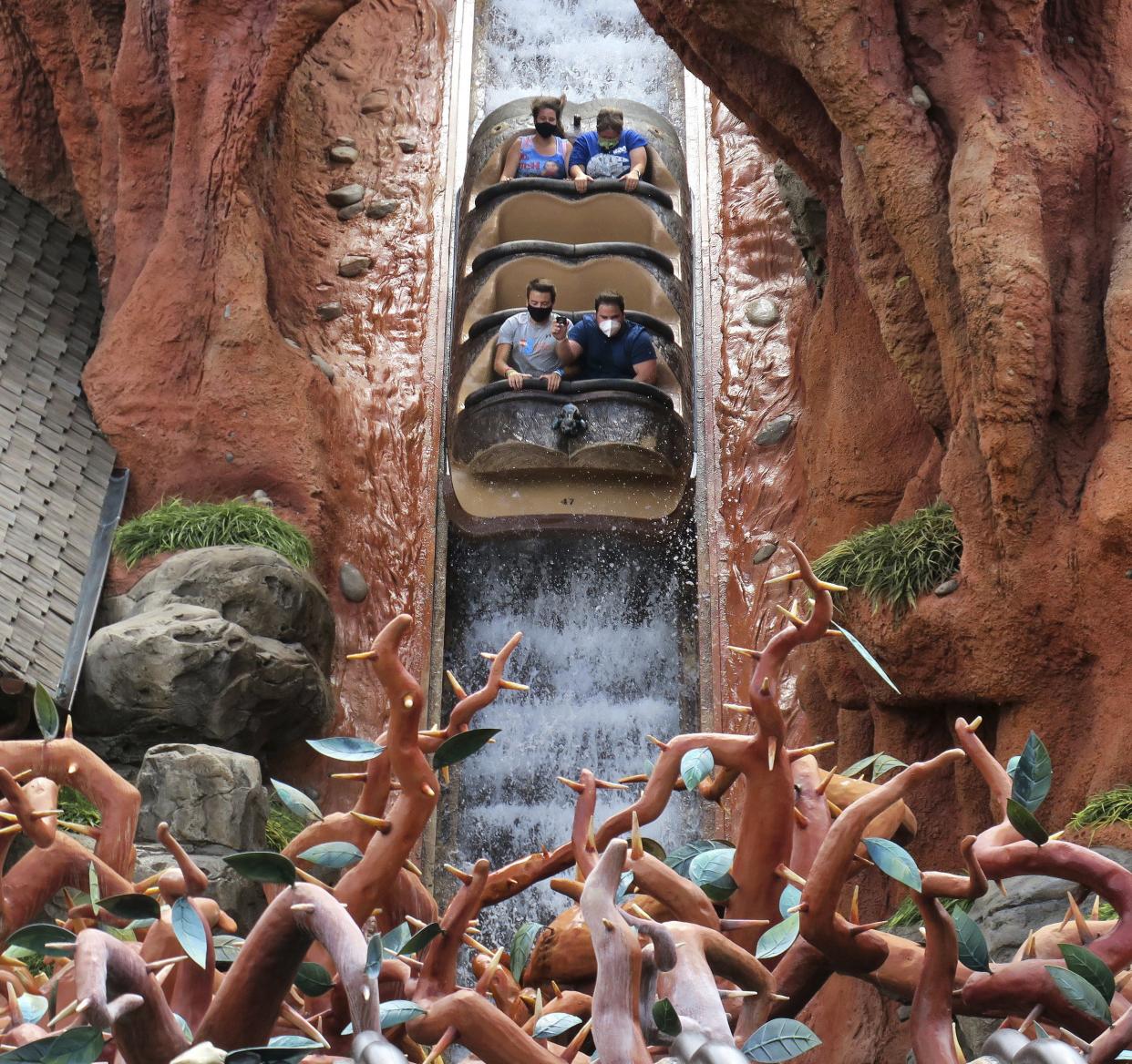 Guests wear masks as required to attend the official reopening day of the Magic Kingdom at Walt Disney World while taking the big plunge on Splash Mountain at the park in Lake Buena Vista, Fla., on Saturday, July 11, 2020.