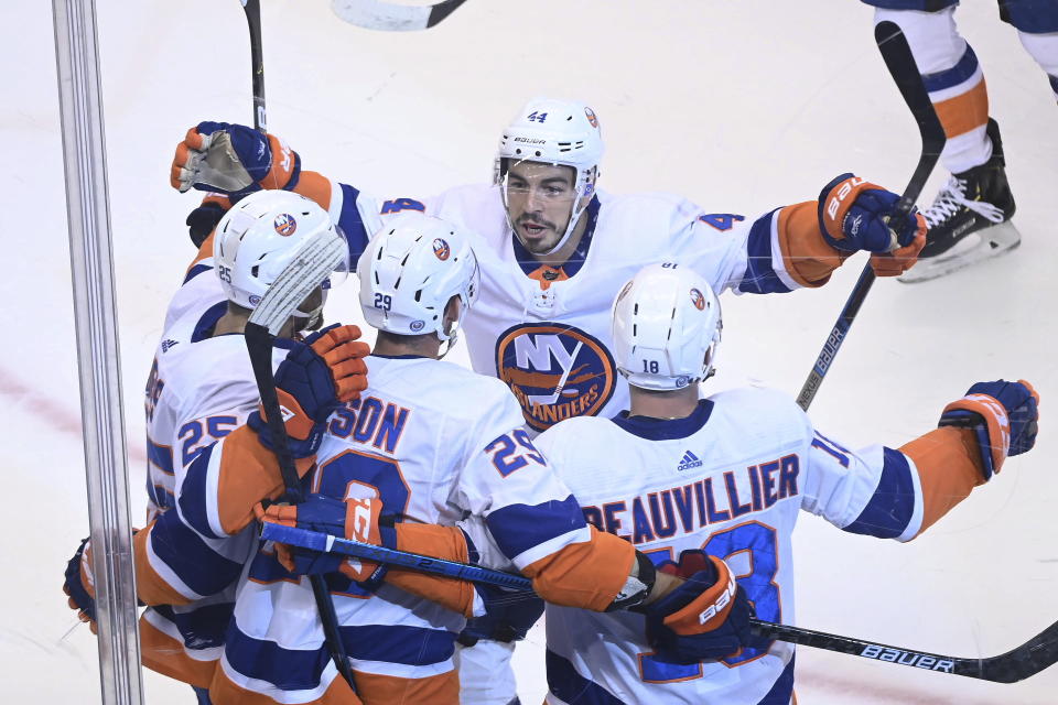 New York Islanders left wing Anthony Beauvillier (18) celebrates his goal against the Washington Capitals with teammates Devon Toews (25), Brock Nelson (29) and Jean-Gabriel Pageau (44) during the first period of an NHL Stanley Cup playoff hockey game in Toronto on Thursday, Aug. 20, 2020. (Nathan Denette/The Canadian Press via AP)