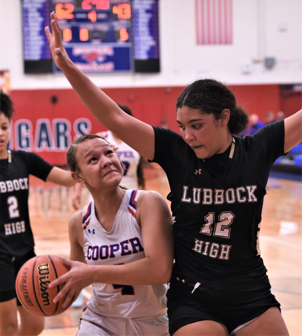 Cooper's Ashlynn French, left, eyes the basket as Lubbock High's Faith Ford defends in the second half.
